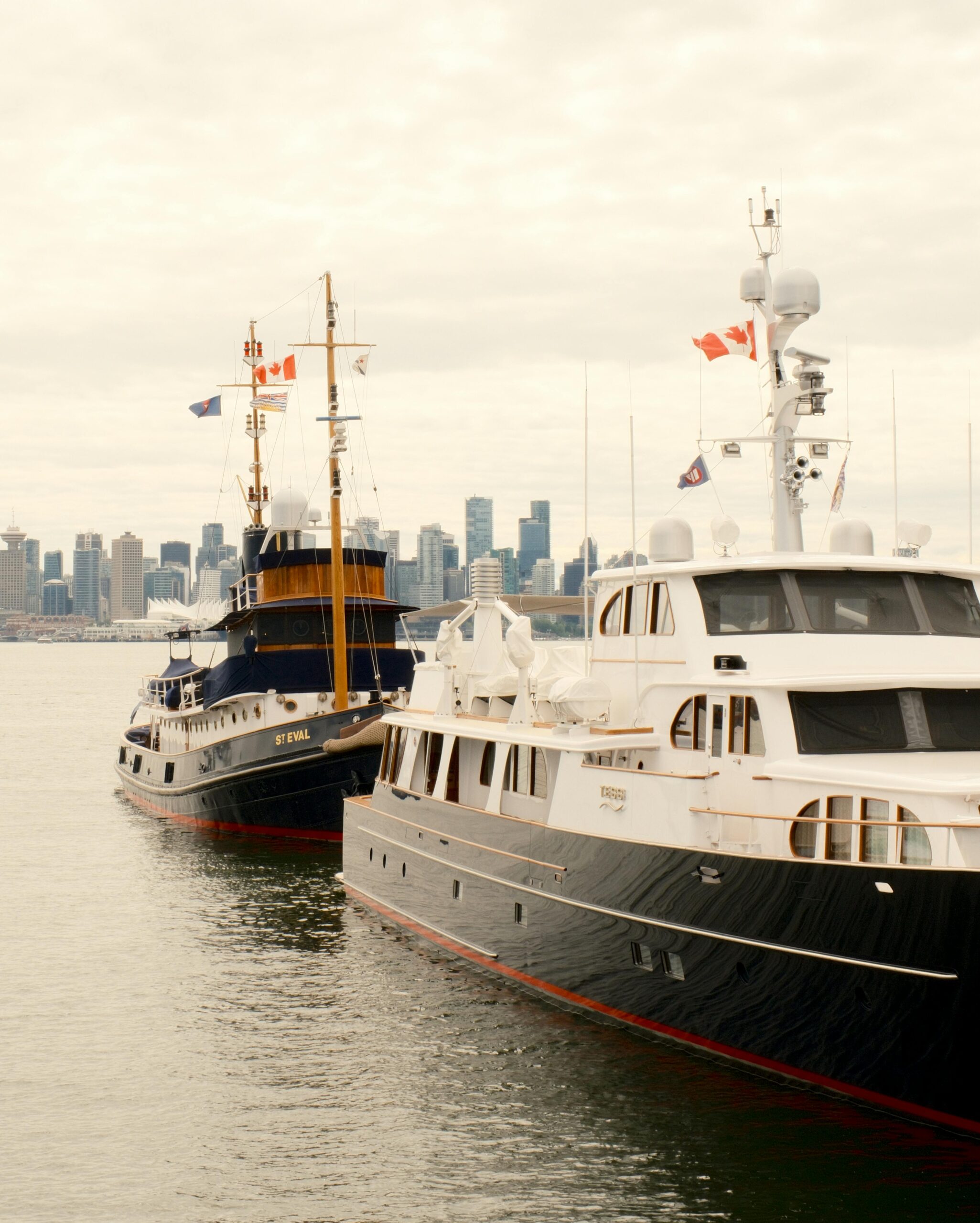 Elegant yachts docked in North Vancouver with the city skyline in the background.
